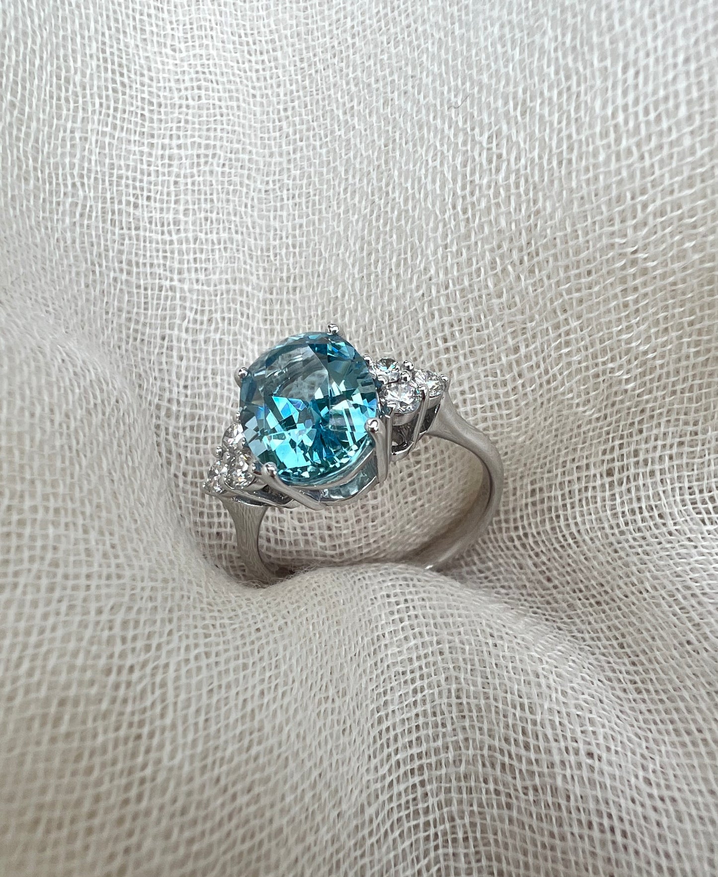 Oval Aquamarine ring with trio of diamonds.