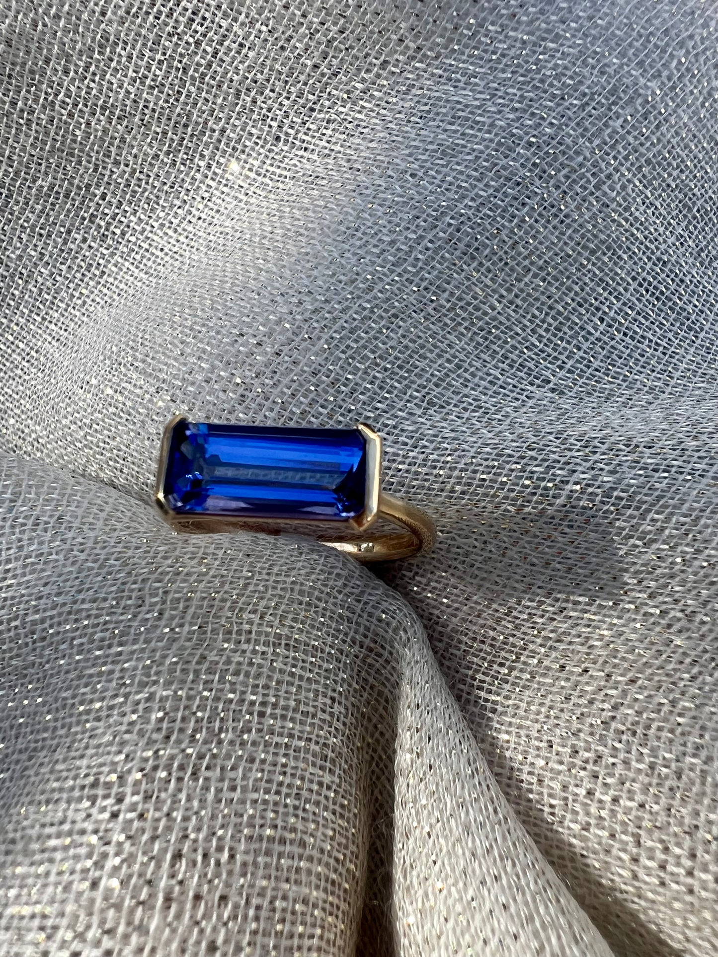 Tanzanite Emerald cut side set ring.