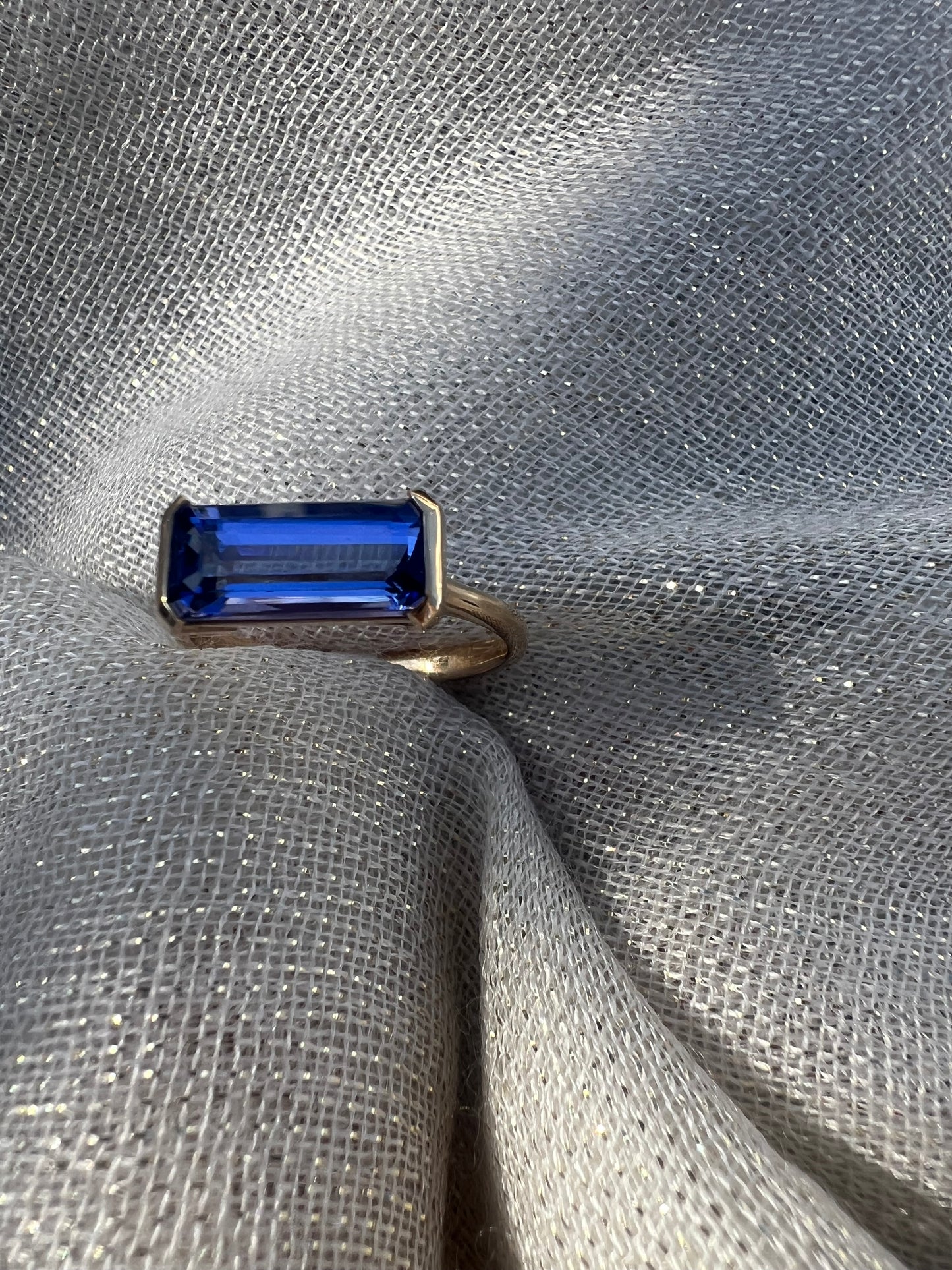 Tanzanite Emerald cut side set ring.