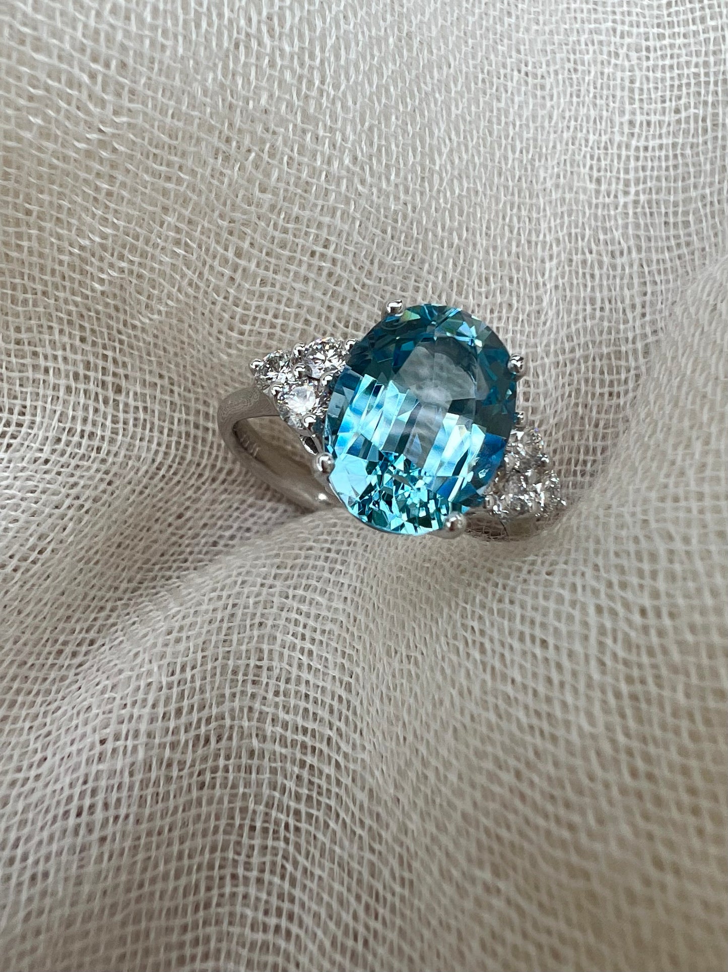 Oval Aquamarine ring with trio of diamonds.