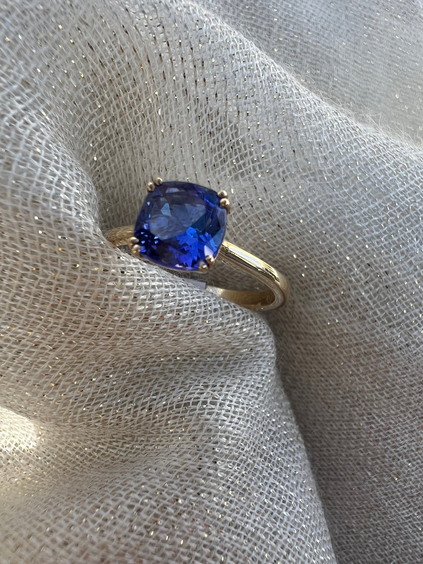 Cushion cut Tanzanite ring in yellow gold.