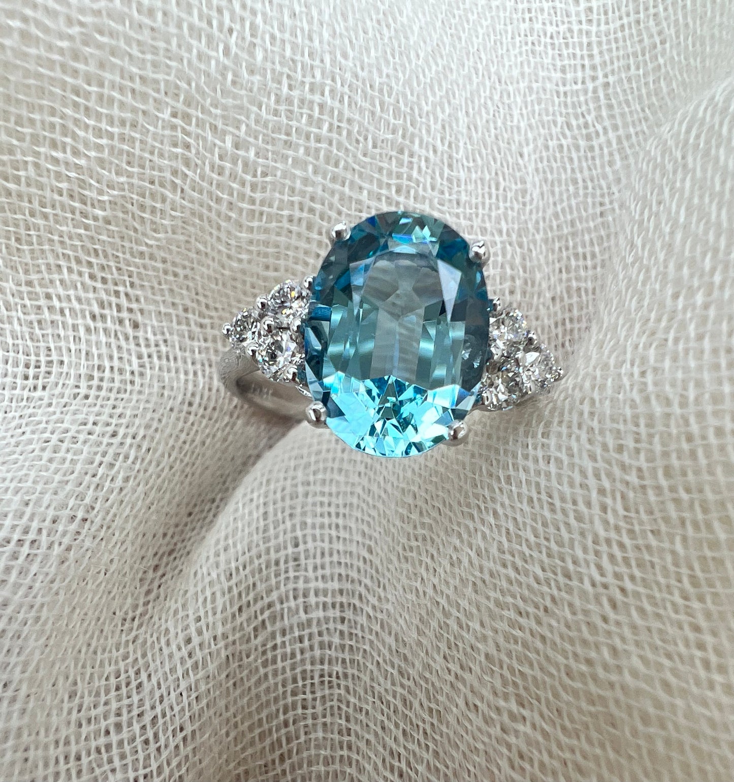 Oval Aquamarine ring with trio of diamonds.